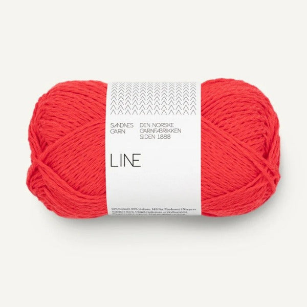 Ball of bright coral orange yarn with a white label on a white background