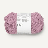 Ball of pinkish purple yarn with a white label on a white background