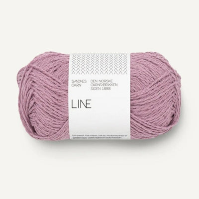 Ball of pinkish purple yarn with a white label on a white background