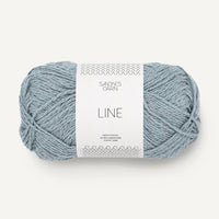 Ball of light blue yarn with a label on a white background