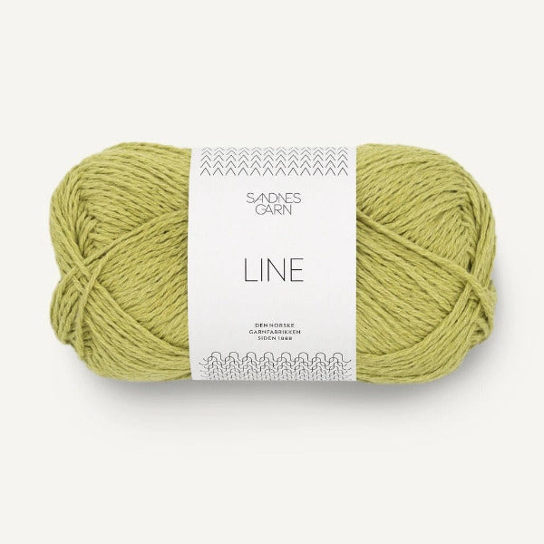 Ball of yellow green yarn with a label on a white background