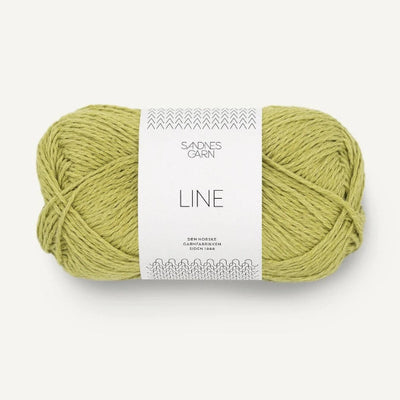 Ball of yellow green yarn with a label on a white background