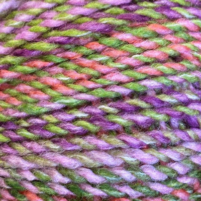 Close-up of multicolored yarn with shades of pink, green, and purple.