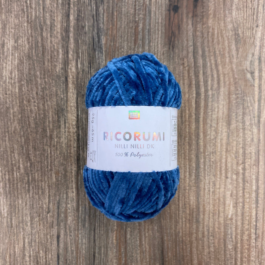 Blue skein of yarn with a label on a wooden surface