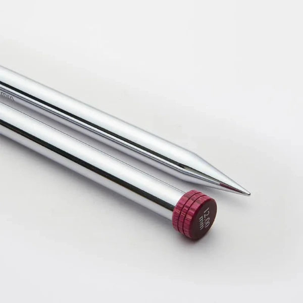 Close up view of shiny metal knitting needles on a white background