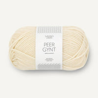 Ball of cream yarn with a label on a white background