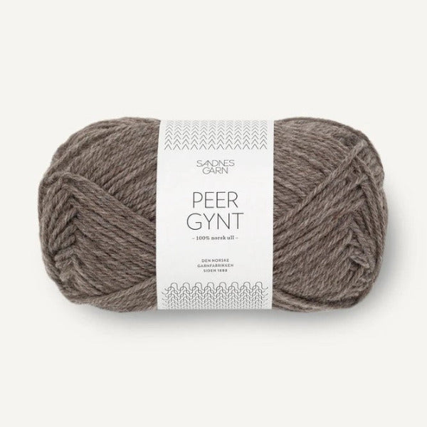 Ball of light brown yarn with a label on a white background