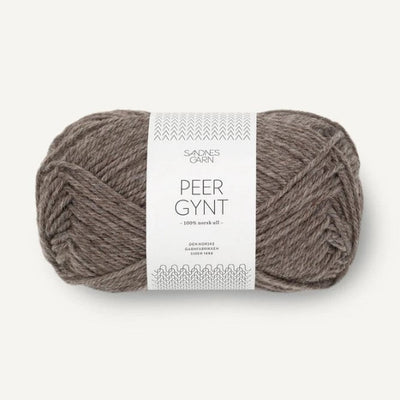 Ball of light brown yarn with a label on a white background