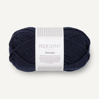 Navy blue ball of yarn with a label on a white background