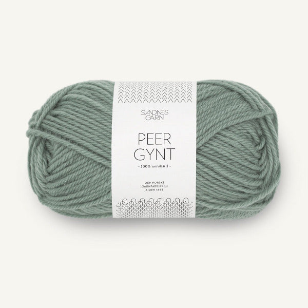 Ball of sage green yarn with a label on a white background