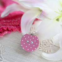 Pink polka dot row counter on a white fabric background