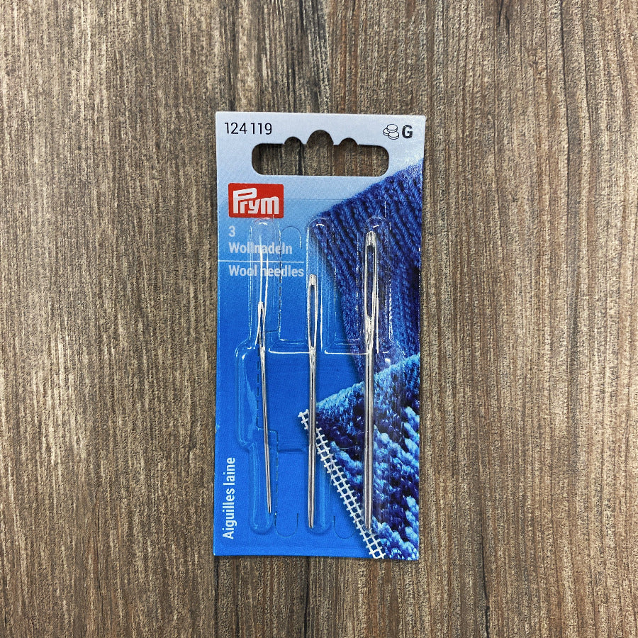 Pack of 3 wool needles on a wooden surface
