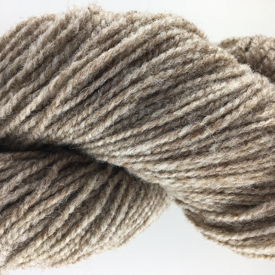 Close-up of a skein of brown yarn on a white background