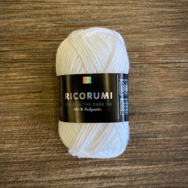 Ball of white yarn with a Ricorumi label on a wooden surface