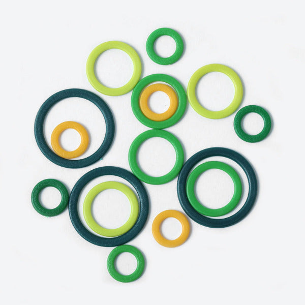 Colorful plastic round stitch markers on a white background