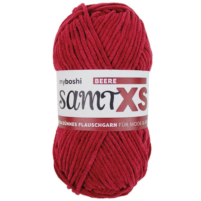 Red chenille yarn ball with a label on a white background