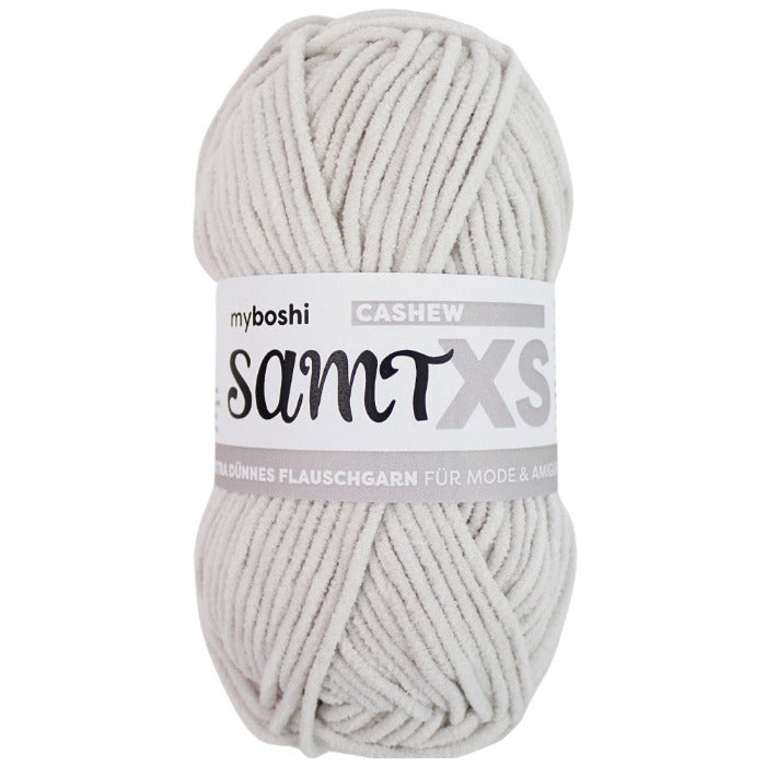 Pale grey chenille yarn ball with a label on a white background