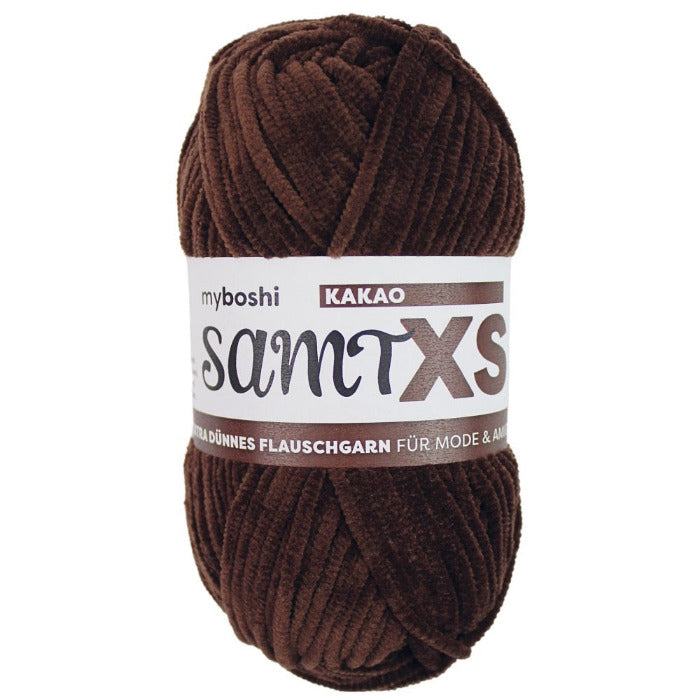 Brown chenille yarn ball with a label on a white background
