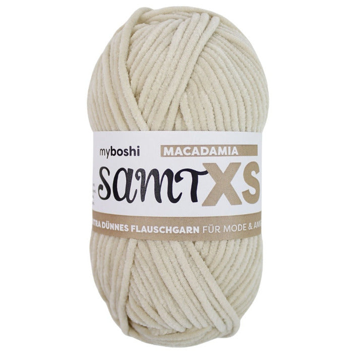 pale beige chenille yarn ball with a label on a white background