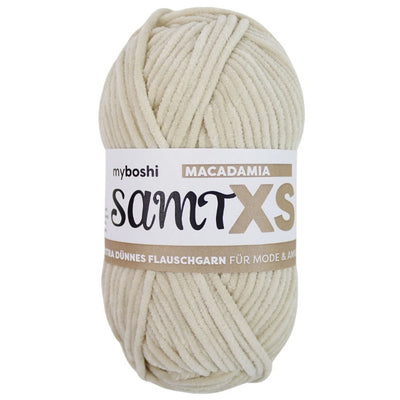 pale beige chenille yarn ball with a label on a white background