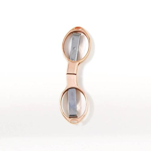 Rose gold folding scissors on a white background