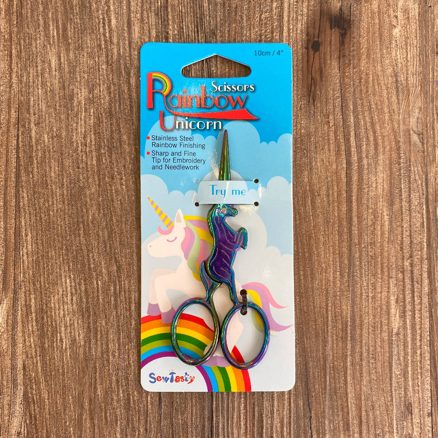 Unicorn-themed scissors in packaging on a wooden surface