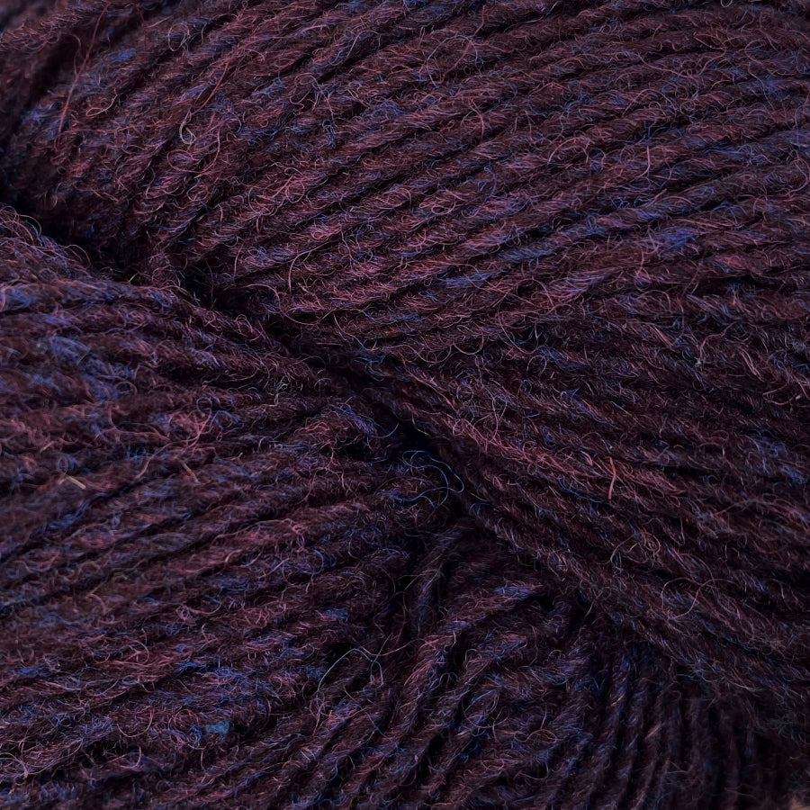 Close-up of a skein of dark burgundy and blue heathered yarn