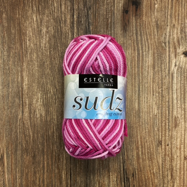 Pink yarn ball with Estelle Sudz label on a wooden surface