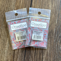 Two packages of ChiaoGoo Swivel Adapters, one labeled Small and one labeled Large, placed on a brown wood surface.