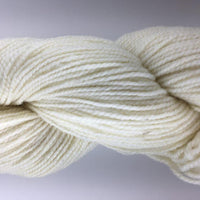 Close-up of a skein of cream-colored yarn on a light gray background