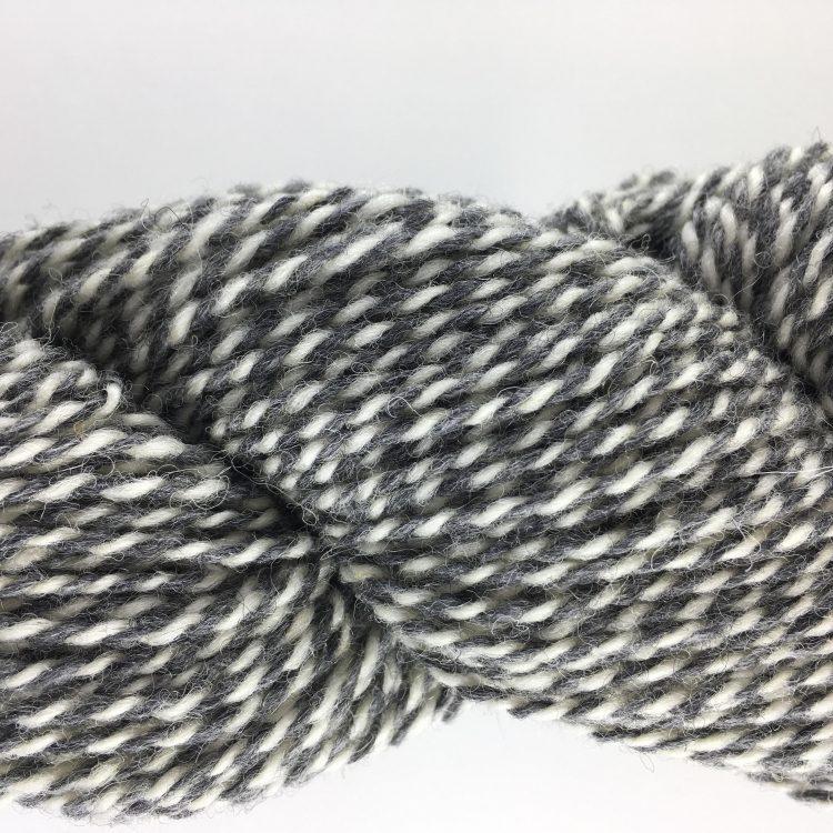 Close-up of gray and white yarn on a light gray background