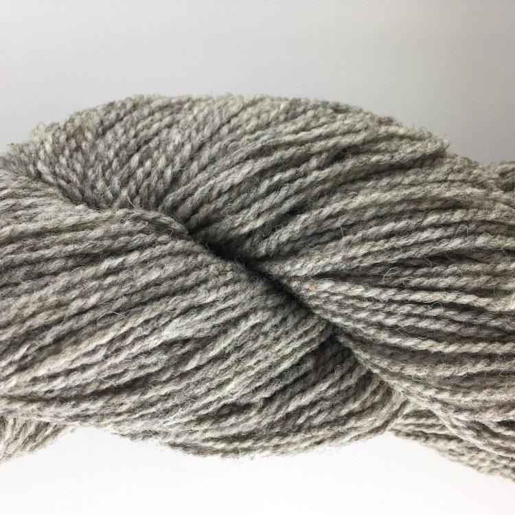 Close-up of pale brown heathered yarn on a white background