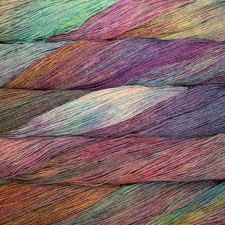Close-up of colorful yarn strands in various shades of purple, pink, and blue.