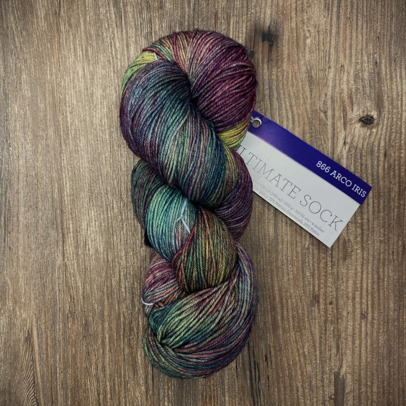 Multicolored skein of yarn with a label on a wooden surface