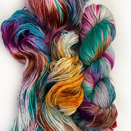 Multicolored skein and loose yarn on a white background