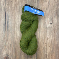 Green skein of yarn with a label on a wooden surface