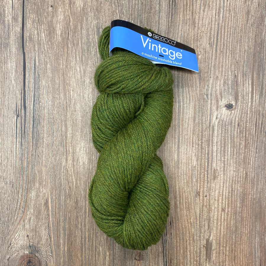 Green skein of yarn with a label on a wooden surface