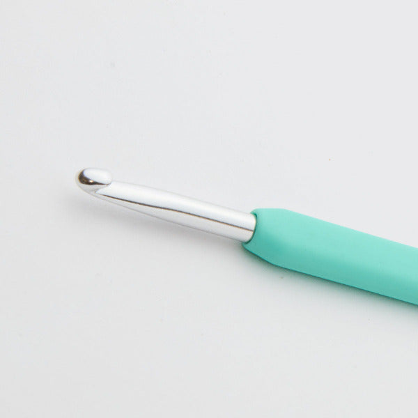 Teal crochet hook on a light gray background