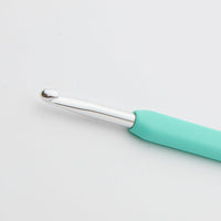 Teal crochet hook on a light gray background