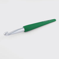 Green-handled crochet hook on a white background