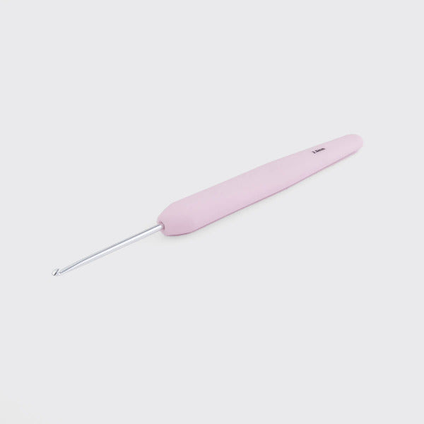 Pale pink crochet hook on a light gray background