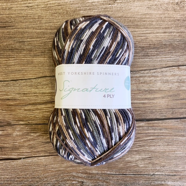 Multicolored yarn skein with a label on a wooden surface